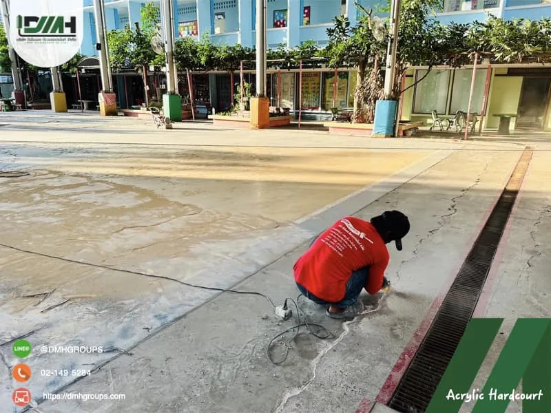 ช่างซ่อมรอยแตกพื้นสนามก่อนทาสี